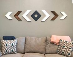 a living room with couches and pillows on the floor in front of a gray wall