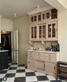 a kitchen with black and white checkered flooring next to a dining room table