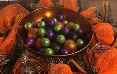 a metal bowl filled with assorted colored chocolate eggs