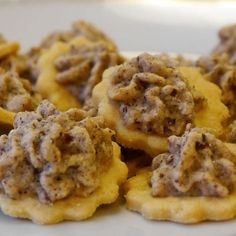 small cookies with meat on them sitting on a plate