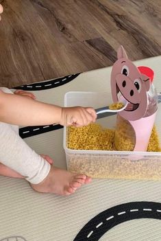 a child eating cereal from a container with a cow head cut out of it's side