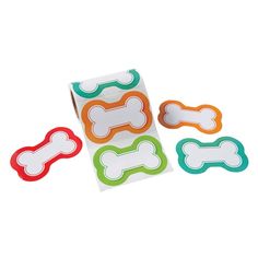 four dog bone magnets are shown in different colors and shapes, with one on top of the other