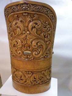 an intricately carved wooden container on display