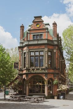 an old brick building with a clock on it's front and side windows in the middle