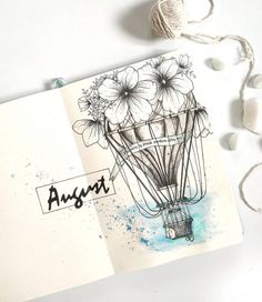 an open notebook with some flowers on it and the words august written in black ink