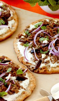 three pizzas with different toppings on a cutting board