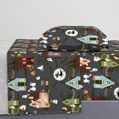 two pieces of luggage sitting next to each other on top of a box with different designs