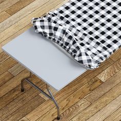 a black and white checkered table cloth on top of a small metal table with a chair underneath it