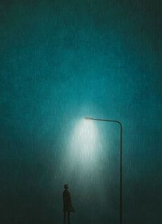 a person standing under a street light in the rain at night with a green background