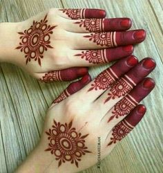 two hands with henna tattoos on them, one is red and the other is white