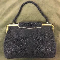 This stunning vintage evening bag, dates to the 1950s and is fully beaded with a floral pattern worked in Matt and lustre seed beads. It has a roll over clasp with beaded decoration , a gold tone metal frame and a beaded top handle. It is lined in black satin with an internal pocket. The label inside reads ' Hand Made Foreign' . It measures 8.5" x 6" and remains in excellent vintage condition. Elegant Beaded Evening Bag For Vintage Events, Antique Beaded Evening Bag, Antique Beaded Evening Bag For Party, Vintage Beaded Evening Bags, Antique Beaded Rectangular Evening Bag, Antique Beaded Evening Bag For Formal Events, Vintage Beaded Formal Bags, Vintage Beaded Bags For Formal Occasions, Antique Beaded Bags For Formal Occasions