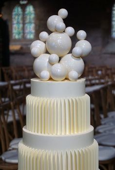 a three tiered cake with white frosting on top