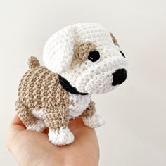 a hand holding a small crocheted dog