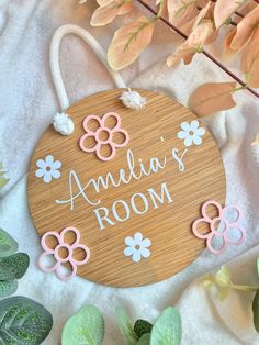 a wooden sign that says amelie's room with flowers on it and leaves around it