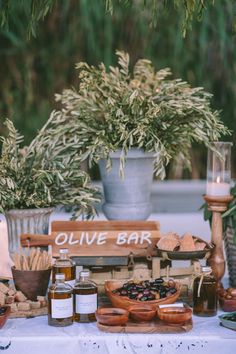 an outdoor bar set up with olives, honey and other condiments on the table