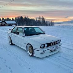 a white car is parked in the snow