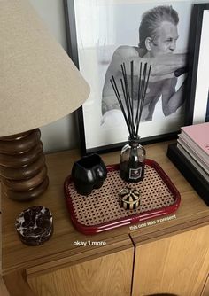 a table with a lamp, candles and pictures on it