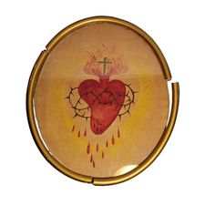 a heart with flames and a cross on it in a gold frame, against a white background