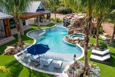 an aerial view of a backyard with a pool and lounge chairs, palm trees, and a gazebo