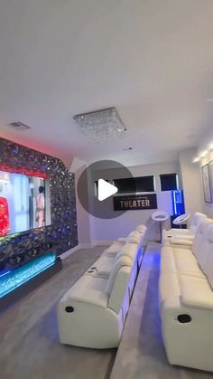 a living room filled with white couches and a flat screen tv mounted to the wall