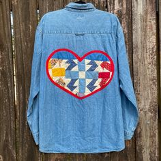 a blue jean jacket with an image of a heart in the center on top of it