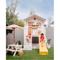 two children playing on a slide in the backyard