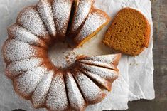 a bundt cake sitting on top of a piece of paper next to a slice of bread