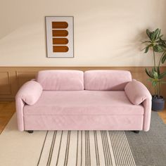 a pink couch sitting on top of a wooden floor next to a potted plant