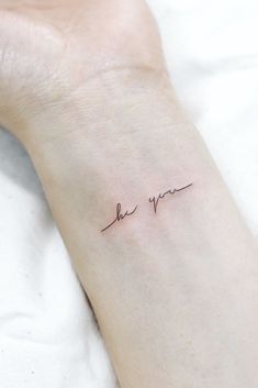 a person with a small tattoo on their arm that says, love you in cursive writing