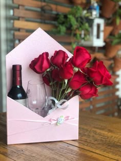 red roses and wine are in a pink box