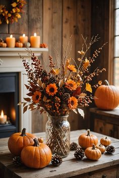 a vase filled with flowers sitting on top of a table next to pumpkins and candles