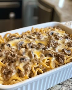 a casserole dish with meat and cheese in it sitting on a kitchen counter