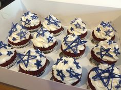 cupcakes decorated with blue and white icing in a box