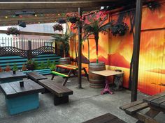 an outdoor seating area with wooden benches and potted plants