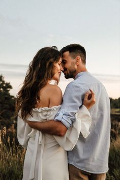 a man and woman embracing each other in the grass