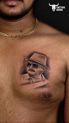 a man with a hat and sunglasses on his chest is shown in this tattoo photo