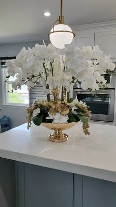 a large white flower arrangement on top of a kitchen counter