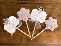 three baby shower cupcake toppers on sticks with snowflakes and silver glitter