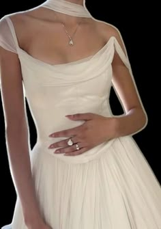 a woman in a white dress with her hand on her hip and wearing a diamond ring