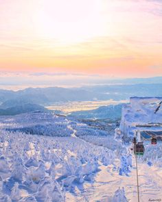 a snow covered ski slope with trees and mountains in the background at sunset or dawn