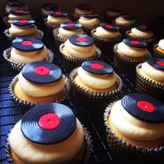 there are many cupcakes with red and black circles on them, sitting on a cooling rack