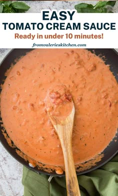 an easy tomato cream sauce in a skillet with a wooden spoon on the side