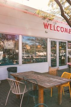 the outside of a restaurant with tables and chairs in front of it that says welcome