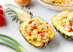 pineapples with rice, peppers and onions on a white surface next to other foods