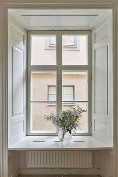 there is a vase with flowers on the window sill