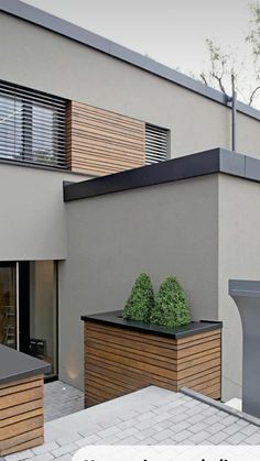 a modern house with wooden planters on the roof