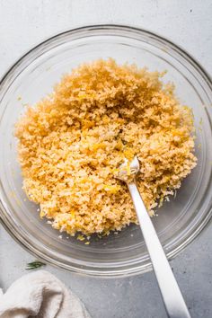 a glass bowl filled with food next to a spoon