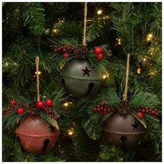 three ornaments hanging from a christmas tree decorated with pine cones, berries and star decorations