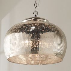 a glass light fixture hanging from a ceiling