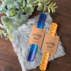 two blue and yellow giraffe print toothbrushes on a fur rug next to a potted plant